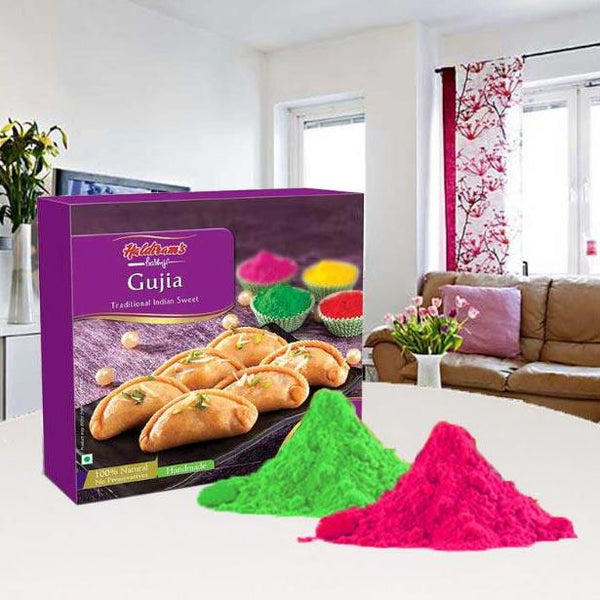 Box of Gujia with Holi colors in a living room setting