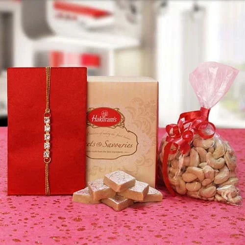 Rakhi gift set with rakhi thread, sweets box, kaju katli, and cashews in festive packaging