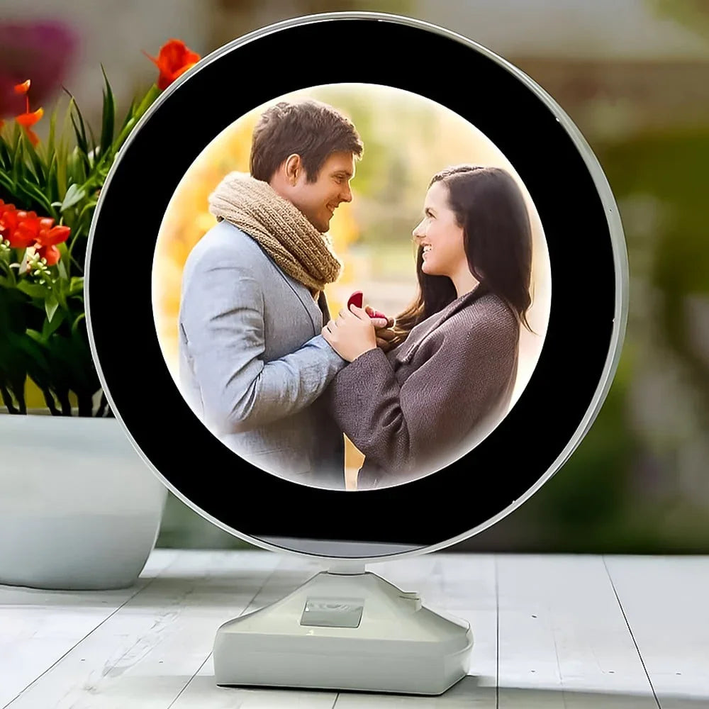 Round photo display with a couple holding hands on a stand, surrounded by flowers.