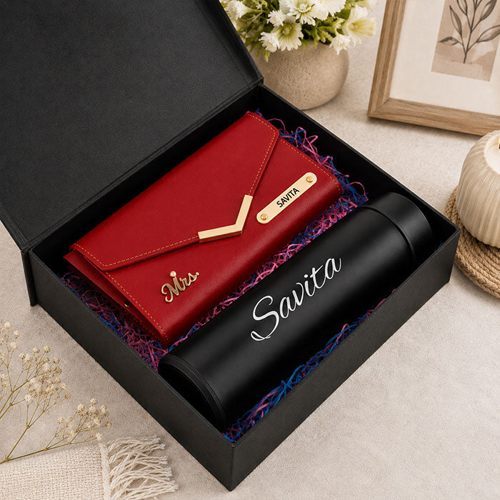Red wallet and black water bottle in a Savita branded box with decorative elements.