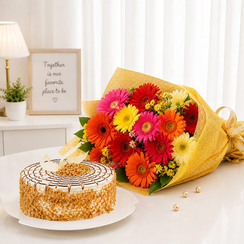 Bouquet of colorful flowers and a cake on a table with a decorative background.