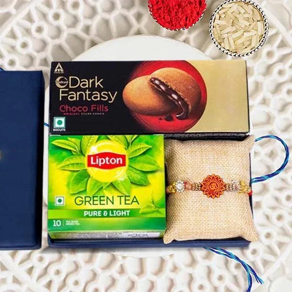 Tea box, dark fantasy chocolate, Lipton green tea, and a decorative item on a textured surface