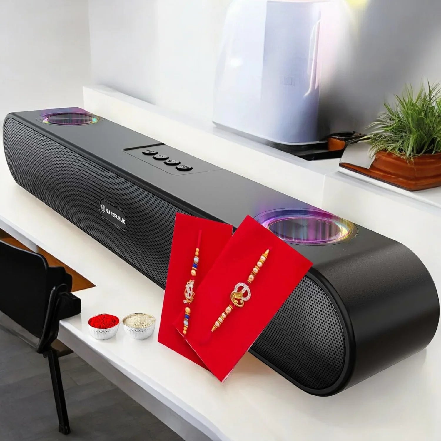 Black electronic device on a white surface with red cards and jewelry
