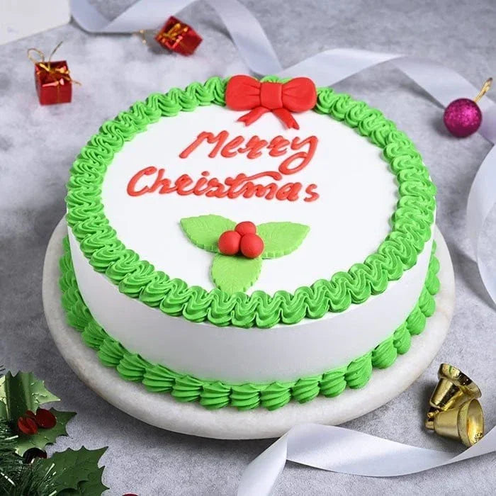 Christmas-themed cake with green and red decorations on a gray surface.