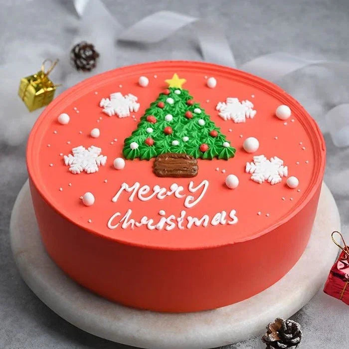 Christmas-themed cake with a tree decoration and 'Merry Christmas' text on a gray background.