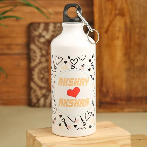 White water bottle with decorative patterns and 'Akshay Akshara' text on a wooden surface.