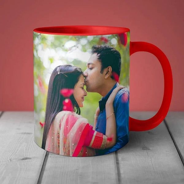 Mug with a printed design of a couple embracing on a wooden surface with a red background