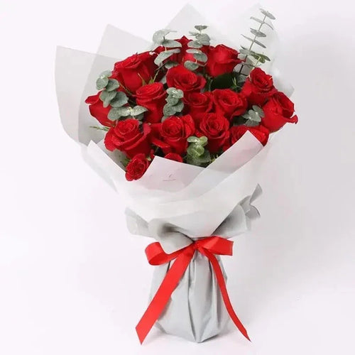 Bouquet of red roses with a red ribbon on a white background