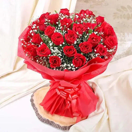 Bouquet of red roses wrapped in red paper on a light background