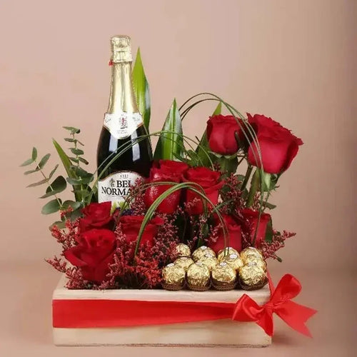 Bottle of Bel'Noma champagne with red roses and Ferrero Rocher chocolates on a beige background