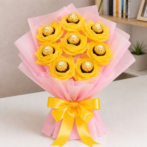 Bouquet of yellow flowers with chocolate candies wrapped in pink paper and a yellow ribbon.