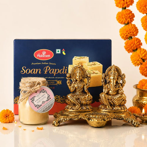 Halkiрамs Soan Papdi box with decorative items and marigold flowers on a light background