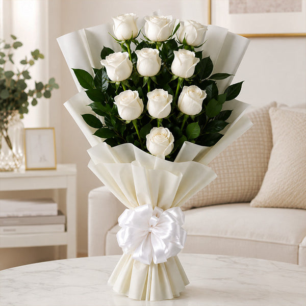 Bouquet of white roses in a decorative paper wrap on a table with a neutral background