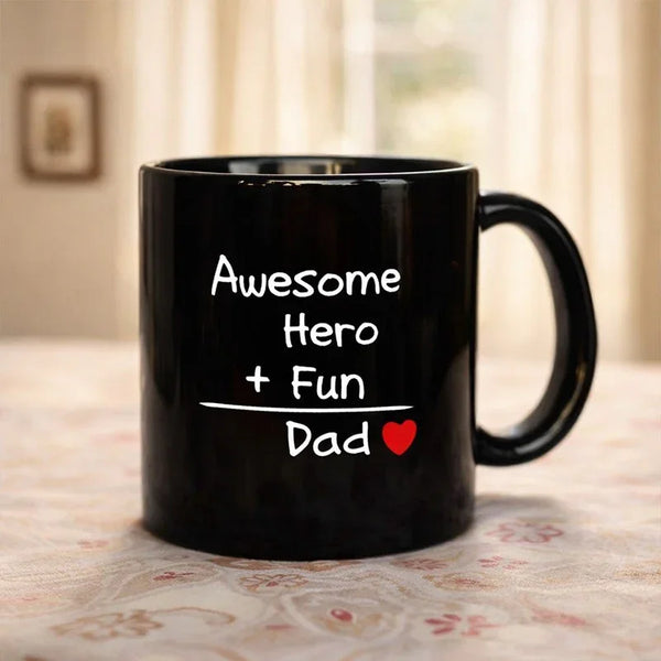 Black coffee mug with 'Awesome Hero + Fun Dad' and a red heart, ideal Father's Day gift.