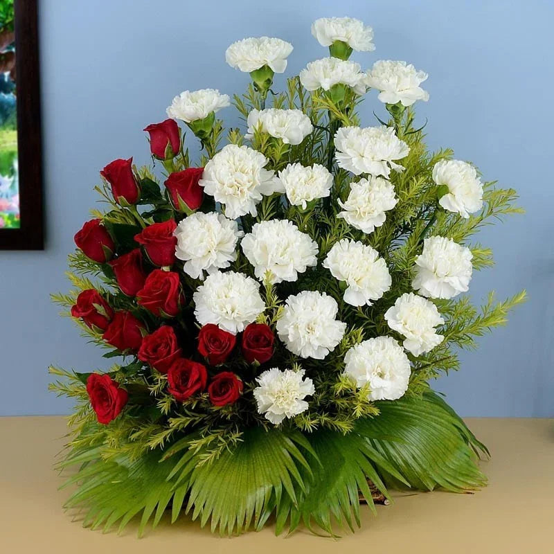 Bouquet of red roses and white carnations on a light blue background