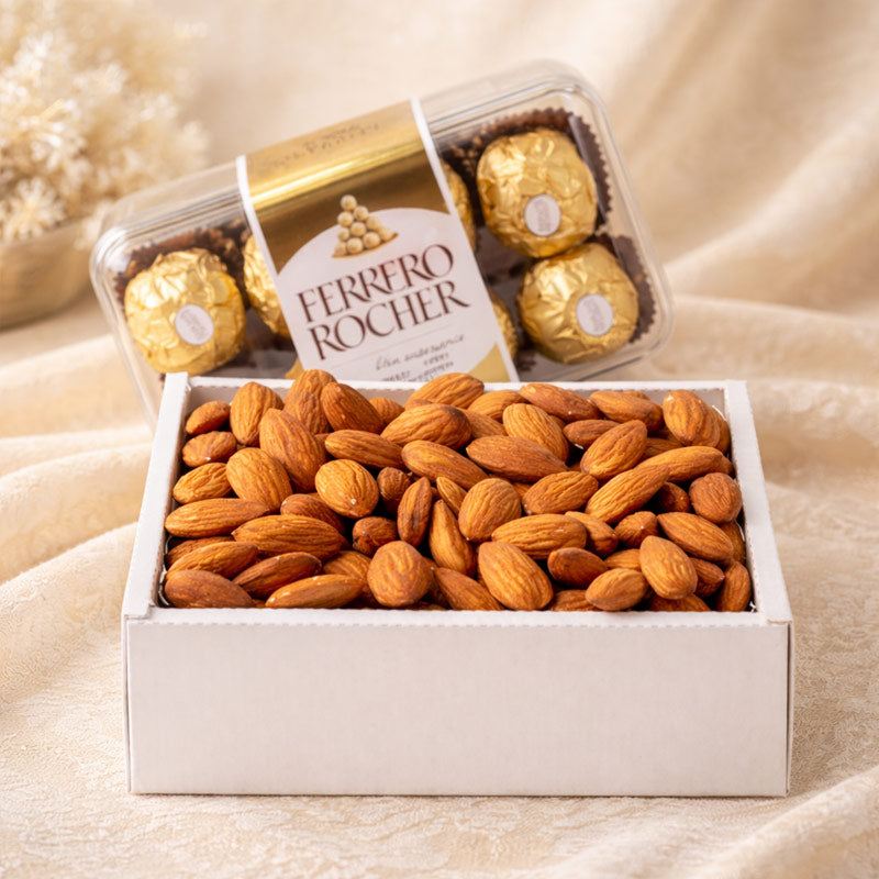 Box of Ferrero Rocher chocolates and almonds on a beige fabric background