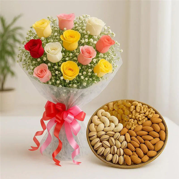 Bouquet of colorful roses with pink ribbon and assorted dry fruits in a tray on a table