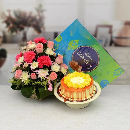 Bouquet of flowers and a small cake with a card on a table.