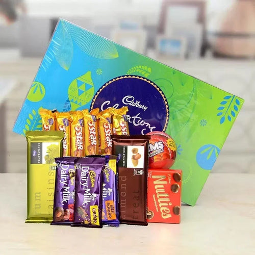 Assorted chocolate bars in front of a Cadbury box on a white surface.