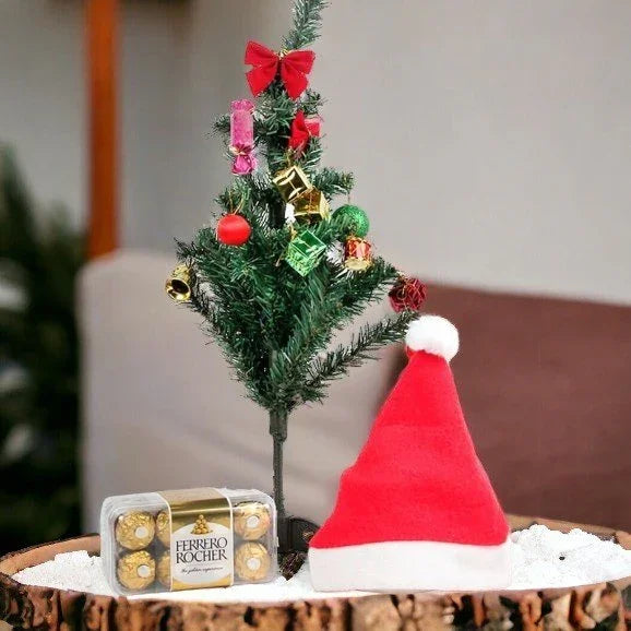 Mini Christmas tree with ornaments, Santa hat, and Ferrero Rocher chocolates on a snowy base