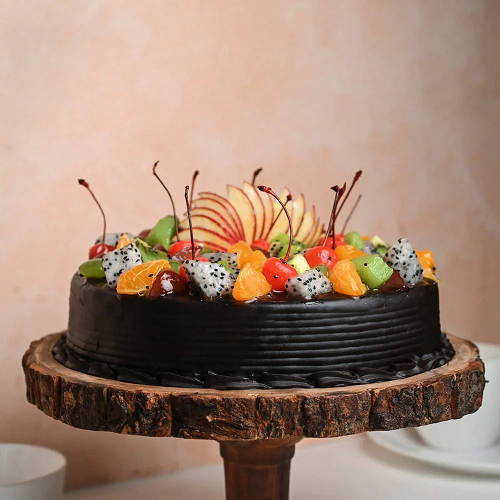Chocolate cake with fruit toppings on a wooden stand against a beige background