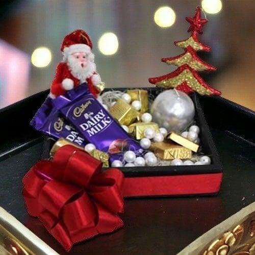 Christmas gift box with Santa figurine, Dairy Milk chocolates, gold candies, and decorative tree