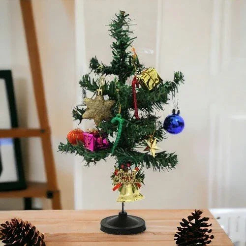 Mini Christmas tree decorated with colorful ornaments and gifts on a table indoors