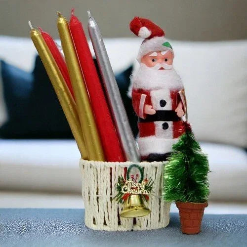 Basket with colorful candles, Santa Claus figurine, mini Christmas tree, holiday decor