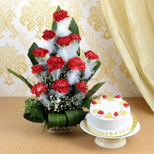 Bouquet of red and white flowers with a small cake on a decorative background