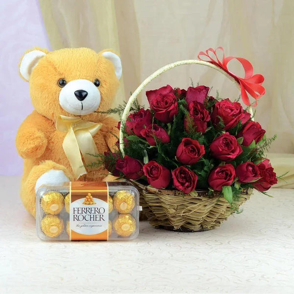 Teddy bear with Ferrero Rocher chocolates and a basket of red roses on a light background