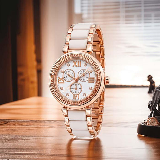 Elegant white and gold women's diamond watch with Roman numerals on a wooden table.