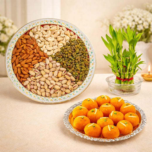 Assorted nuts in a bowl with mandarins and a bamboo plant on a table.