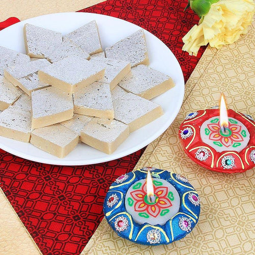 Decorative Diya with star-shaped Kaju Katli on a patterned surface