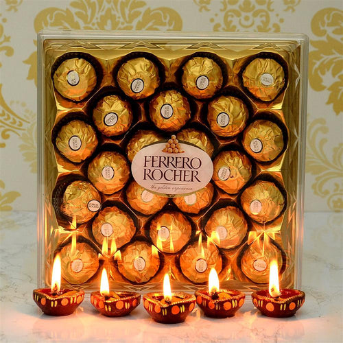 Ferrero Rocher chocolate set with lit Diwali oil Diya on a decorative background