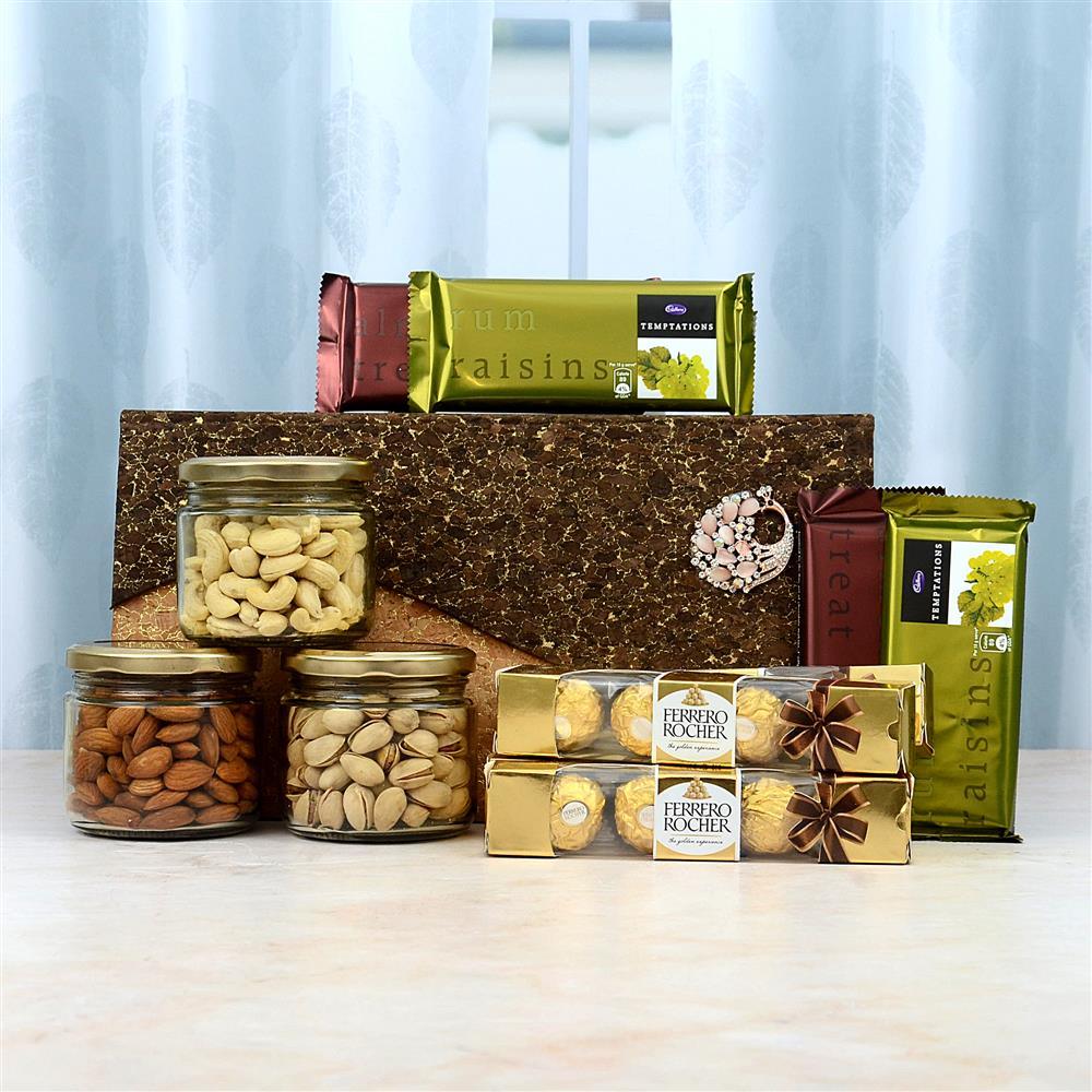 Gourmet gift basket with nuts, chocolates, and candies on a white surface.