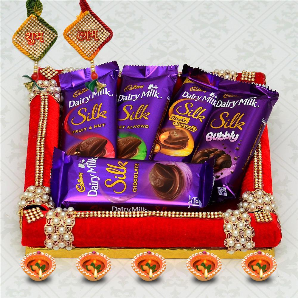 Cadbury Dairy Milk Silk chocolate bars on a decorative tray with festive elements.