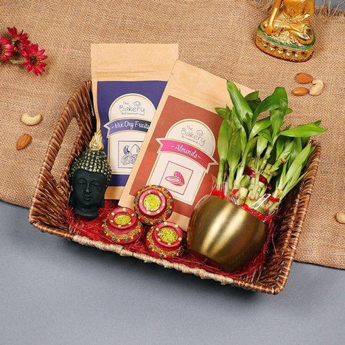 Gift basket with Buddha statue, snacks, and plants diyas
