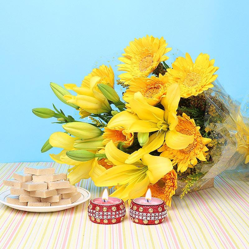 Bouquet of yellow flowers with two small red candles on a striped tablecloth 