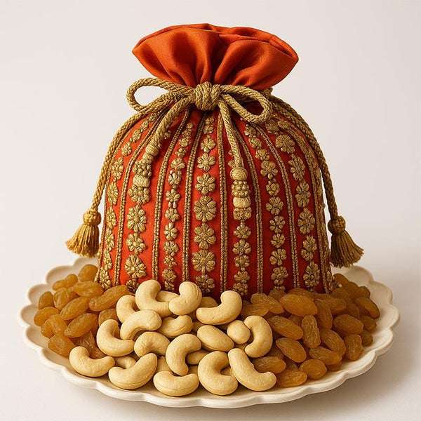 Decorative orange gift pouch with cashews and raisins on a plate, Diwali dry fruit hamper