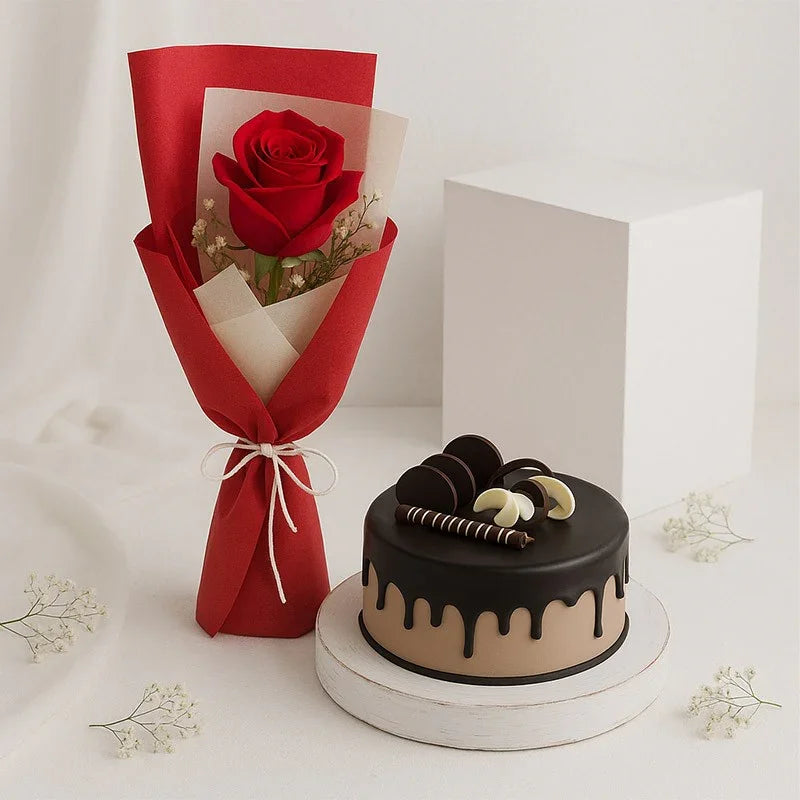 Bouquet of red roses wrapped in red paper with a black and beige cake on a white background