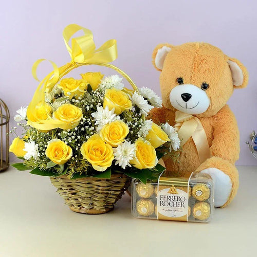 Teddy bear with yellow roses and Ferrero Rocher chocolates on a light background