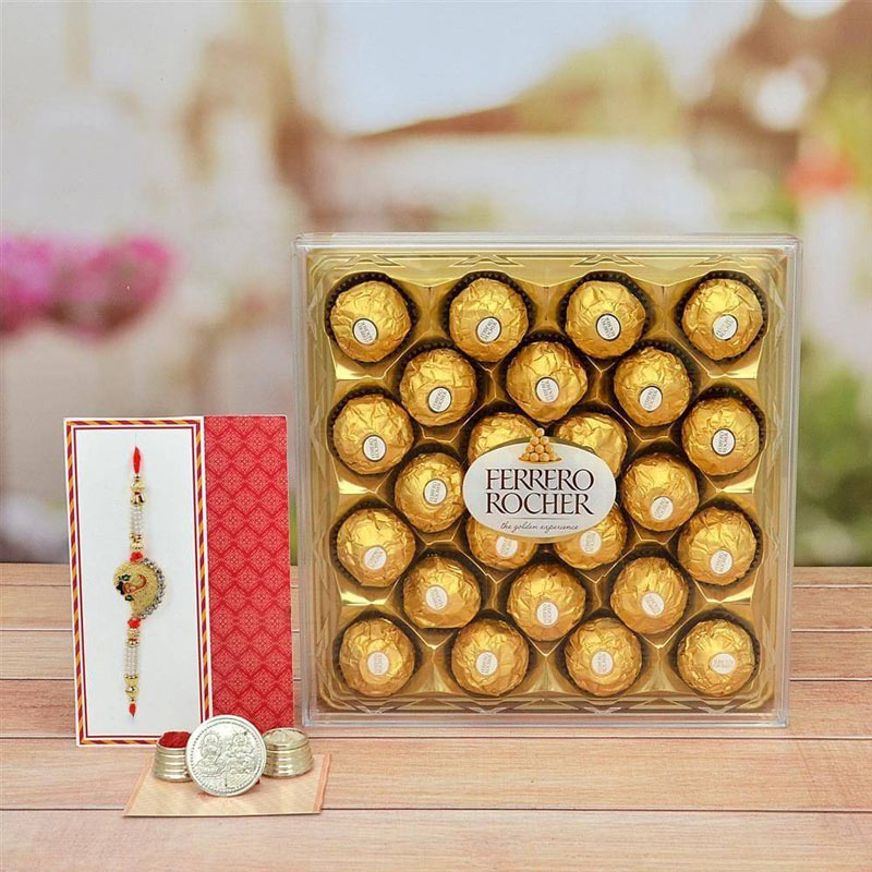 Box of Ferrero Rocher chocolates with a Rakhi and coins on a wooden surface