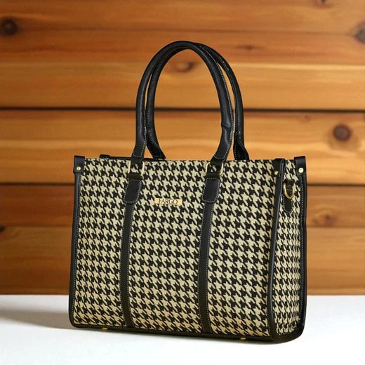 Houndstooth patterned handbag with black handles on a wooden surface