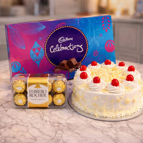 Cadbury Celebrations chocolate box and Ferrero Rocher chocolates with a cake on a marble surface.