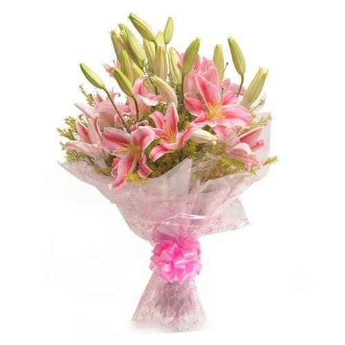 Bouquet of fresh pink lilies wrapped in cellophane with a pink ribbon, suitable for gifting