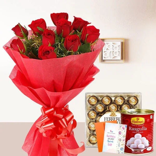 Bouquet of red roses with Ferrero Rocher chocolates and Haldiram's Rasgulla card on a white background