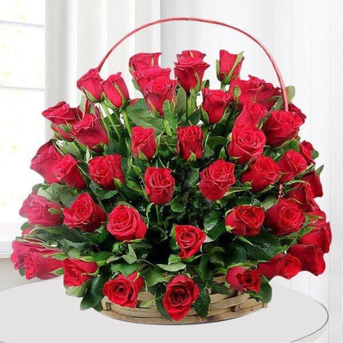 Basket of red roses on a white surface 