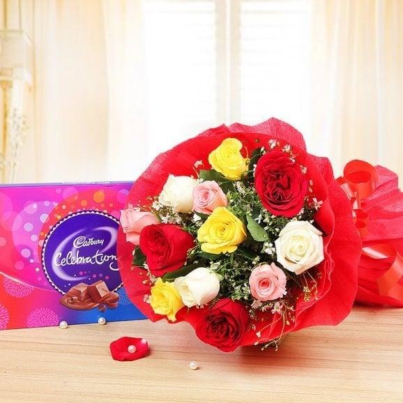 Colorful rose bouquet with Cadbury Celebrations chocolate box on a wooden table