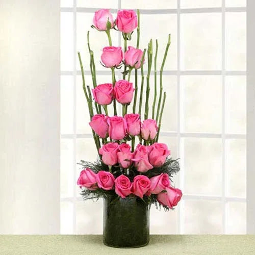 Elegant pink roses arrangement in a glass vase, perfect for gifting and decor.