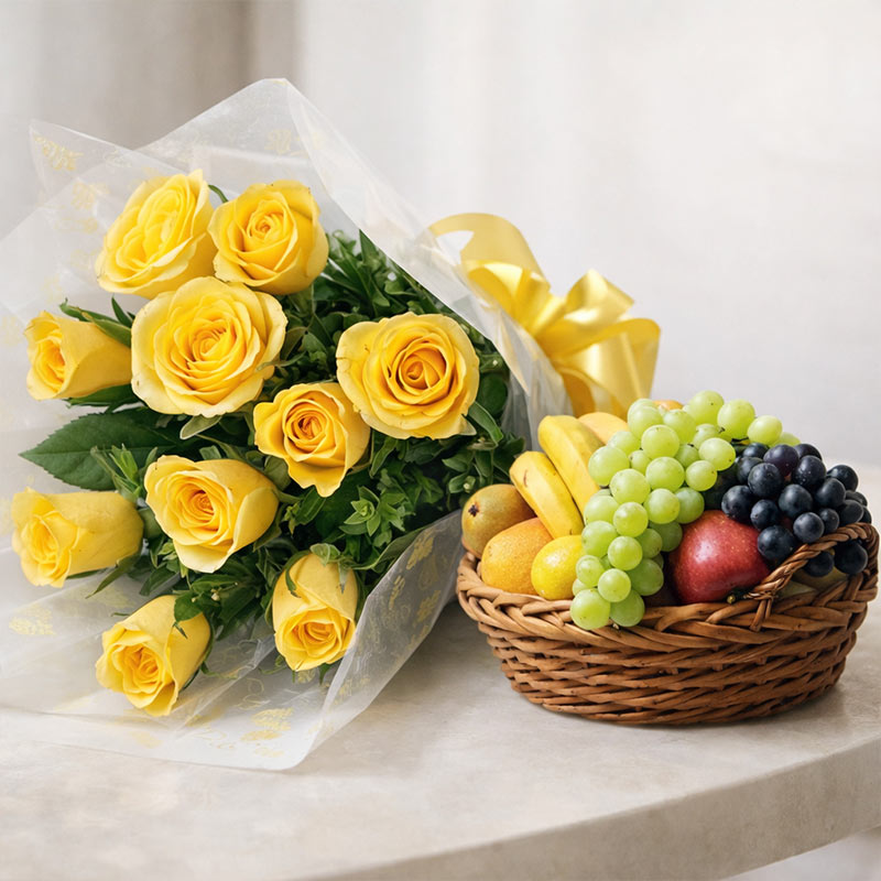 Bouquet of yellow roses with a basket of fruits on a white surface